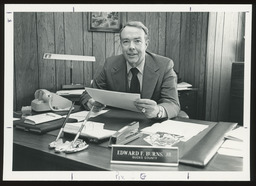 Rep. Burns staged in his office holding papers