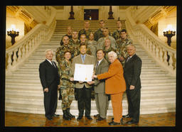National Guard soldiers and Representatives holding a copy of House Resolution 520.