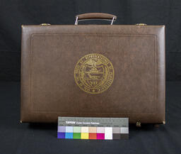 The seal of the Pennsylvania House of Representatives is on the top of the briefcase.
