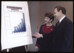 Rep. John Barley and Rep. Mary Ann Dailey stand in front of a poster board "Cumulative Tax Relief 1994-2001"