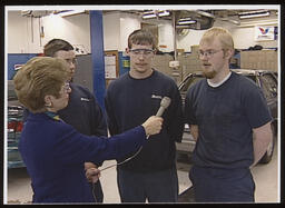 Rep. Mary Ann Dailey interviews three car mechanics students in the car garage.