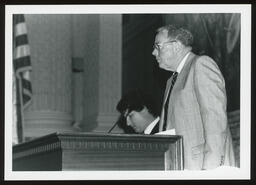 Speaker's podium, Rep. Burns speaking with Steve Thompson the Mace Bearer in the background