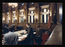 Speaker Robert O'Donnell speaks at the Speaker's Rostrum. To his left is Parliamentarian Clancy Myer. Great view of the Speaker's voting machine and the House Floor.